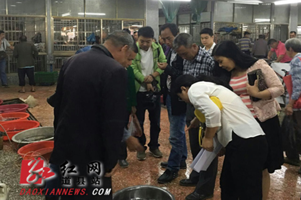 工作人员在农贸市场咨询解答群众现场。