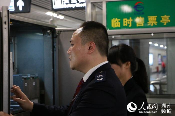 站务人员从售票机中提取硬币箱