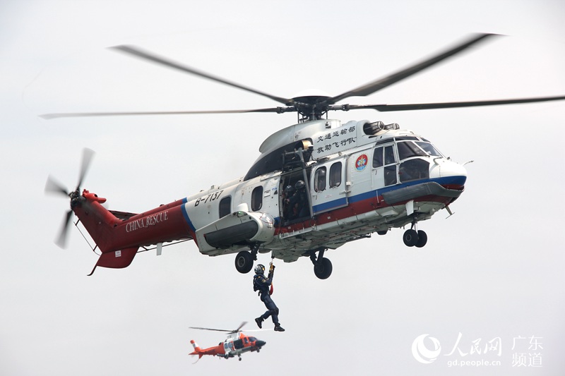 19日,“2016年珠江口国家海上搜救演习”在广东珠江口的桂山岛附近海域成功举行。图为搜救人员转移落水者后返回直升机内。钟哲 摄