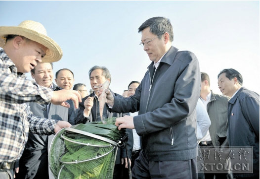 2014年11月14日，在湘江边的竹埠港综合排污口，杜家毫（前右一）现场查看垂钓者钓上的河鱼。刘建强摄