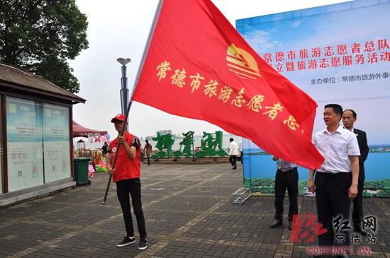 为志愿者服务队授旗。