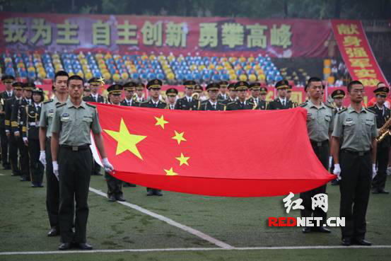 细雨绵绵中，五星红旗依旧鲜艳夺目，与橄榄绿的军装形成鲜明的对比。