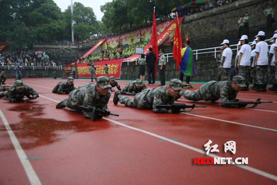 雨中匍匐前进，身着迷彩的他们年轻的脸庞上少了青涩，取而代之的是军人的坚毅顽强。