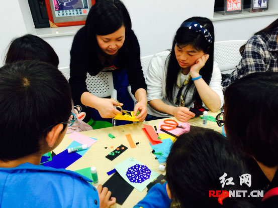 老师耐心指导大家制作剪纸书签。