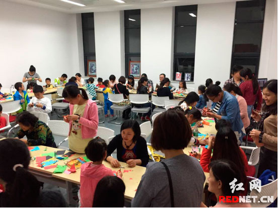 老师现场指导剪纸制作书签。