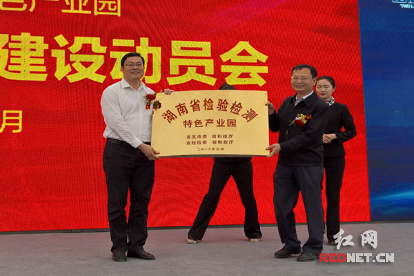 湖南省发改委党组成员、湘西办主任周震虹（右）为湖南省检验检测特色产业园授牌。