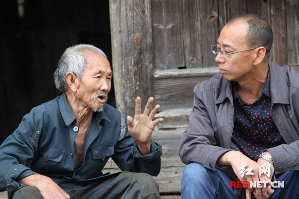 湖南隆回县林业局局长张伯赞(右)在向鸭田镇寨溪村二组卢治良(左)了解春耕生产物资购置情况