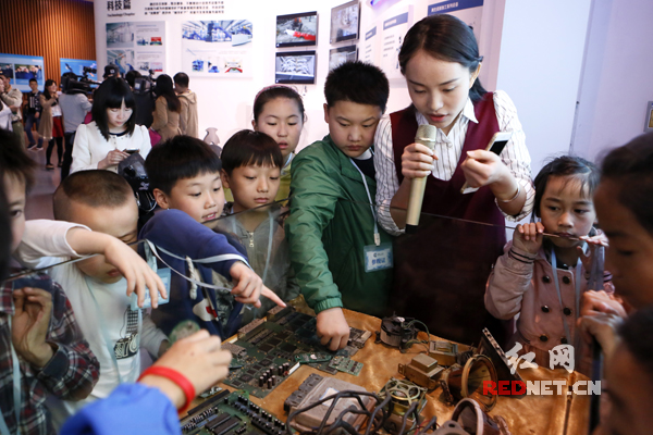 万容科技城市矿产展示馆，工作人员为孩子们讲解废旧家电的经济价值。