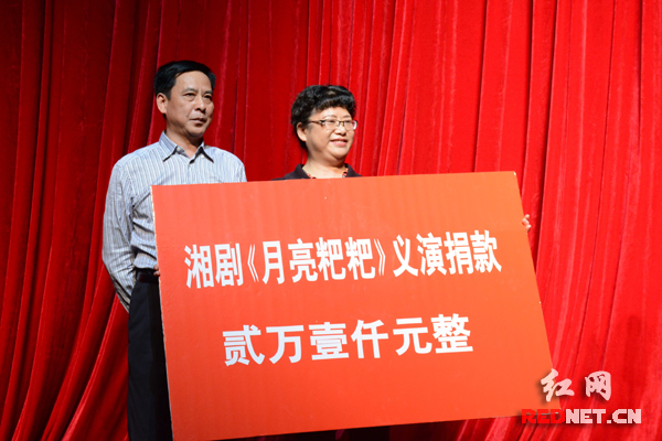 湖南省湘剧院党委书记张克浪（左）代表省湘剧院把《月亮粑粑》首演收入全部捐给江永县岩寺营乡村小学。