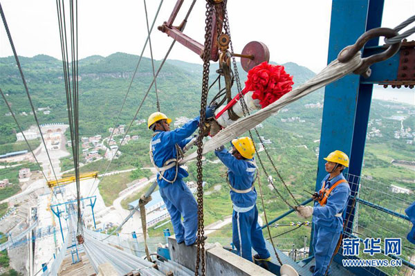 5月30日，技术工人在北索塔上安装最后一根主缆背索。