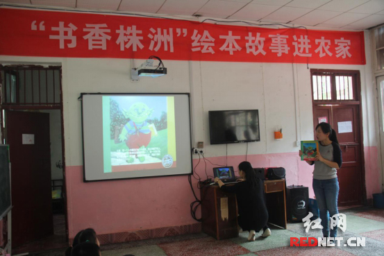 株洲市图书馆的陈老师给小朋友们讲《小魔怪要上学》的故事。