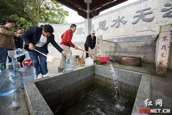 居民在千年古井东沙井边取水。