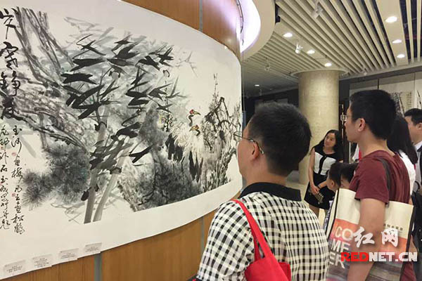 展示现场，市民正在欣赏其中一幅书画作品。