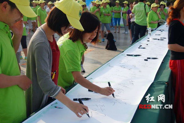 志愿者们在宣传环保的横幅上签下了自己的姓名。