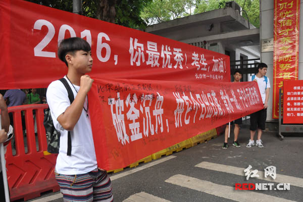 长沙市一中的免考生组“亲友团”拉横幅为同学加油。