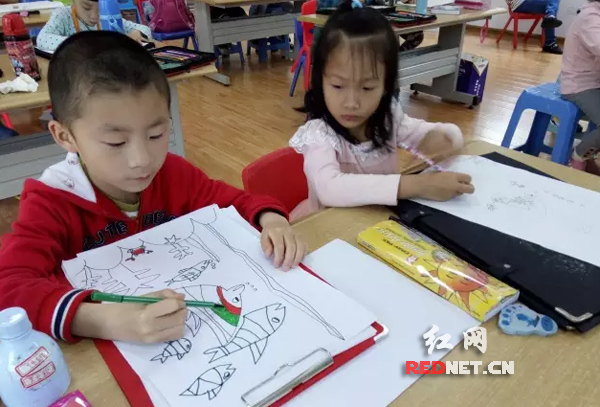 小朋友们练字画画。