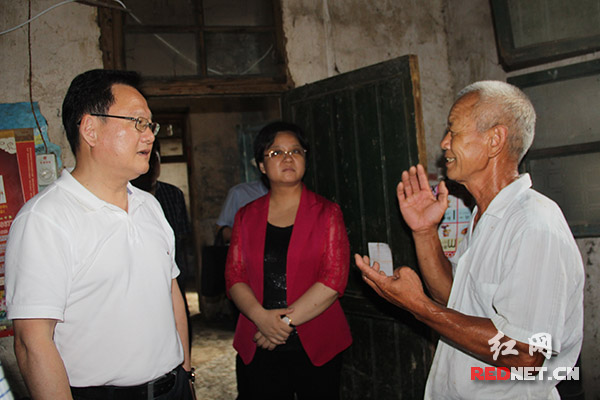湖南省新闻出版广电局党组书记、局长朱建纲（左一）走访慰问火柴岭村贫困户，了解脱贫情况。