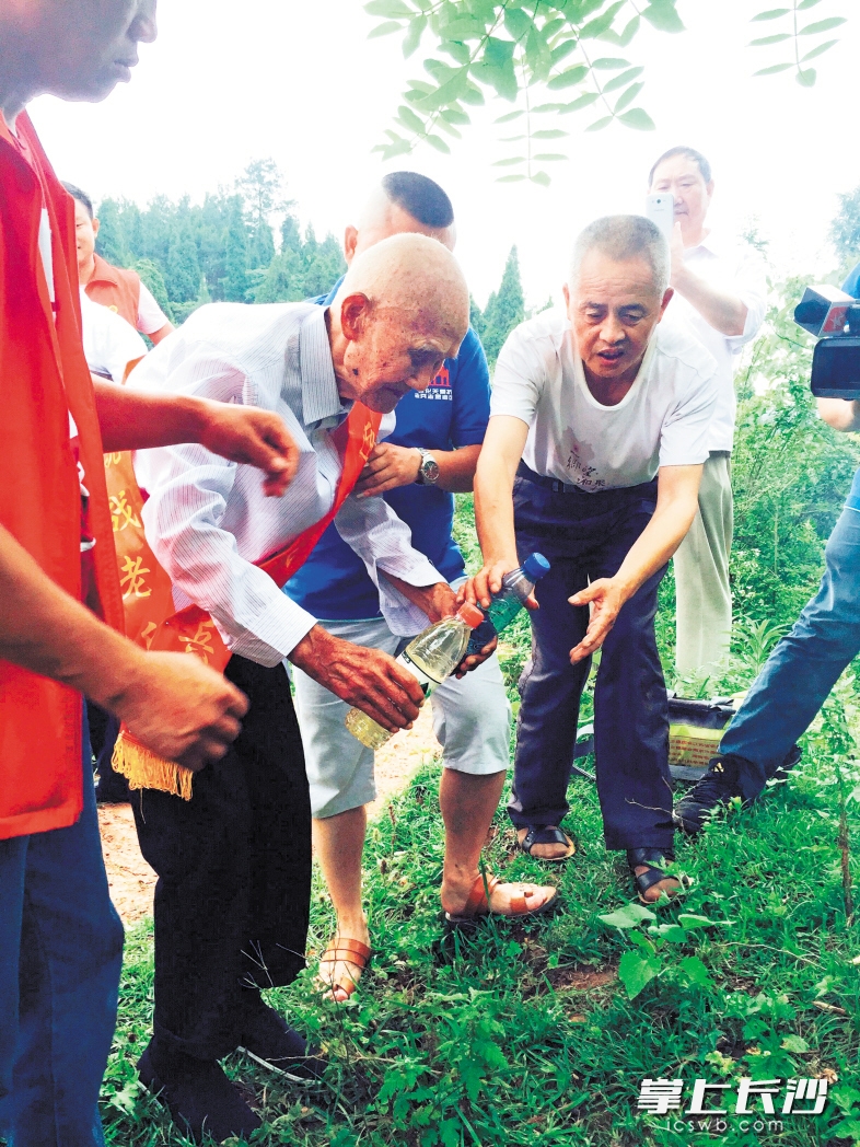 　　在故乡的土地上，向心桂老人取了水、土各一份带回浏阳，作为永远的念想。                     长沙晚报通讯员 欧阳稳江 摄