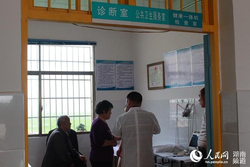 诊断室里，村里正在为村民解释一体机检查的各项指标
