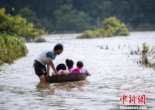 江西都昌部分乡村公路被淹村民涉水用木桶推孙女上学