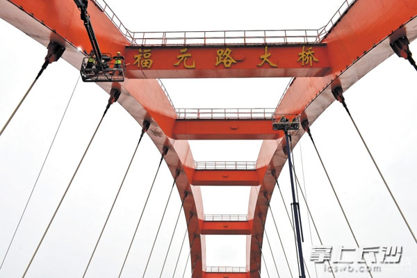昨日，在福元路大桥上，工人们正在对桥拱内侧加装点光源，改造后的大桥将更加通明透亮。长沙晚报记者王志伟摄
