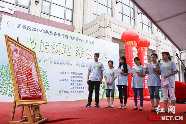 两型志愿者宣读“携手节能低碳，共建芙蓉碧水蓝天”的倡议书。