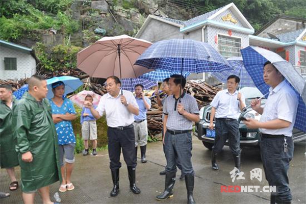 胡金华（前排左二）了解明溪口镇那叉村当地群众防汛情况。