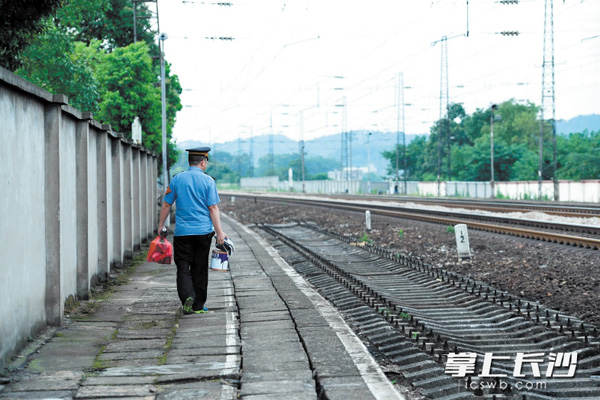 完成了最后一班岗，谭智龙提着放在站里的个人物品走出车站。
