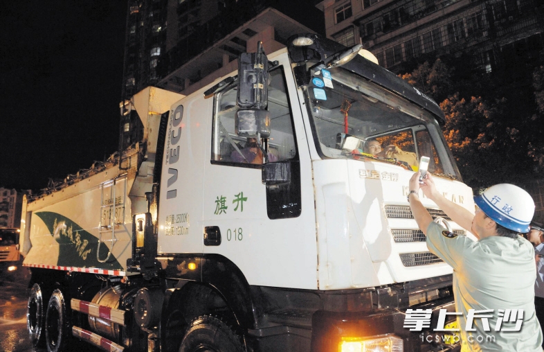 前晚，市城管局执法队员通过渣土管理平台智能终端系统进行扫描操作，了解渣土车的运营情况。长沙晚报记者 周柏平 摄
