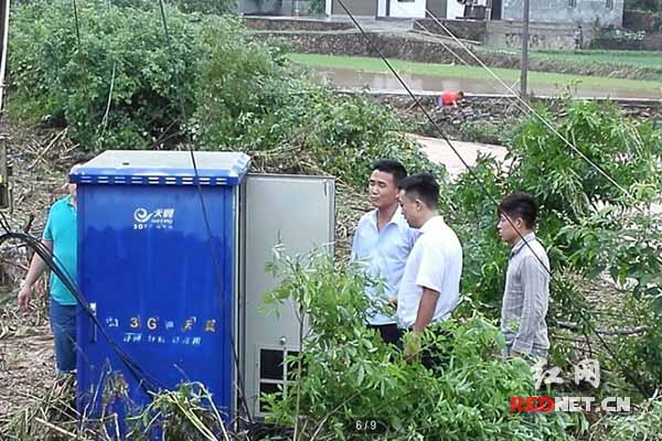 长沙电信员工冒雨检修交接箱。