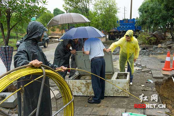 湘西电信员工冒雨检查抢修通信管道。
