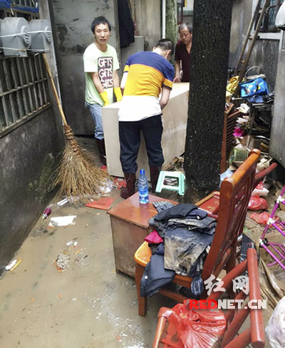 暴雨过后，长沙市宁乡县检察院全体干警帮助受灾社区老人清淤排污。