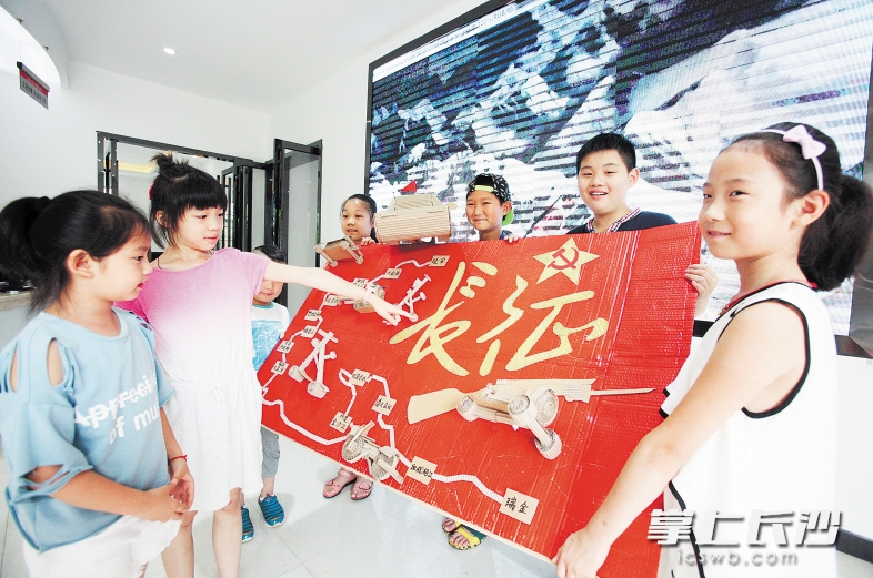 昨日，在芙蓉区荷晏社区，孩子们展示用瓦楞纸制成的“长征行军图”。 长沙晚报记者 熊伟 摄