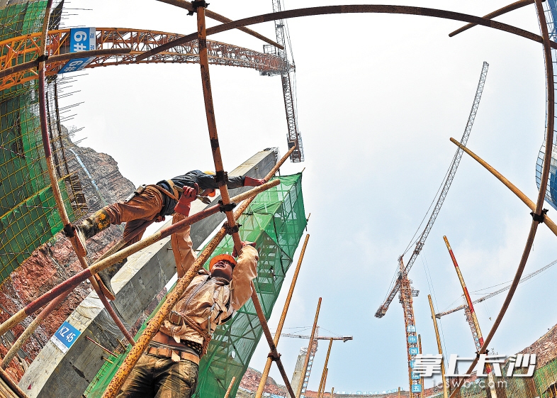 昨日，在位于湖南湘江新区的湘江欢乐城建设现场，400多名工人冒着高温在深坑内紧张施工，古铜色的肌肤是他们的统一“标签”。 均为长沙晚报记者王志伟 摄