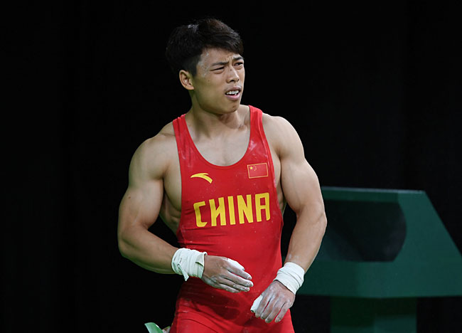 8月8日，在2016年里约奥运会举重男子62公斤级决赛中，中国选手谌利军在抓举比赛中抽筋，无奈弃赛。新华社记者程敏摄 