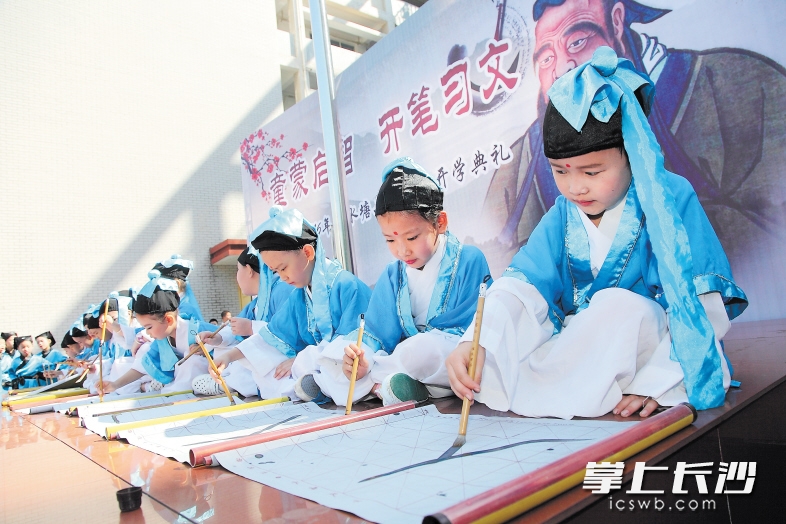昨日，清水塘二小，小一新生在孔子画像前举行“开笔礼”，一笔一划书写大大的“人”字。长沙晚报记者 陈飞 摄