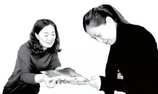 王庆（左）在给顾客介绍旅游项目