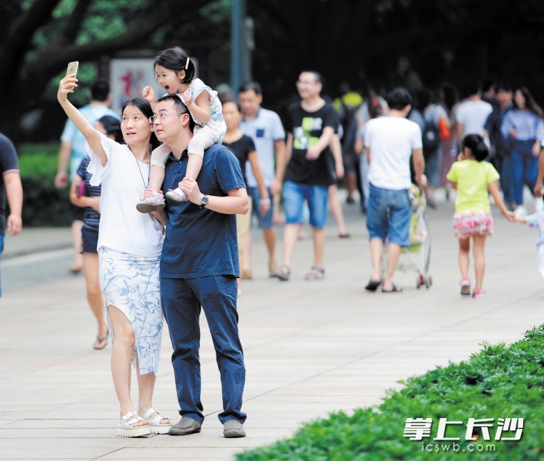 人人遵守秩序，出游心情会更好。图为烈士公园内一家三口享受快乐时光。长沙晚报记者 余劭劼 摄