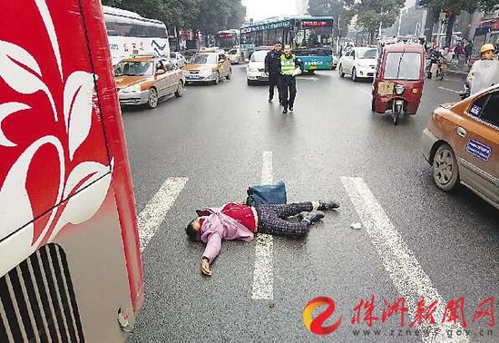 12月12日，车站路，一名女子被“撞”后躺在地上不愿去医院（记者谢慧摄）