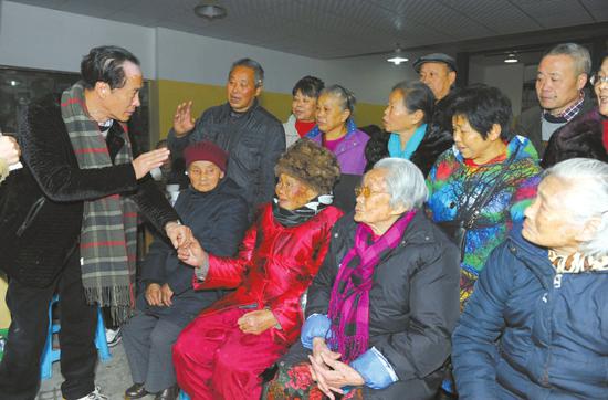 　　12 月17日，刘祖树（红衣者）接受晚辈的祝贺。刘祖树今年103岁，两个妹妹也都已经90多岁，当日刘家后人为他举行坝坝宴庆生。