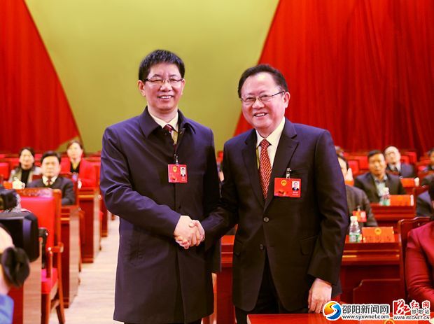 刘事青当选为市人民政府市长。龚文密与刘事青握手。