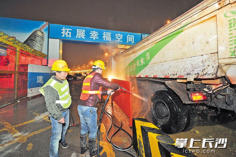 昨晚，在长沙地铁5号线朝阳站建设工地，洗车工正在冲洗环保渣土车。 长沙晚报记者 王志伟 摄