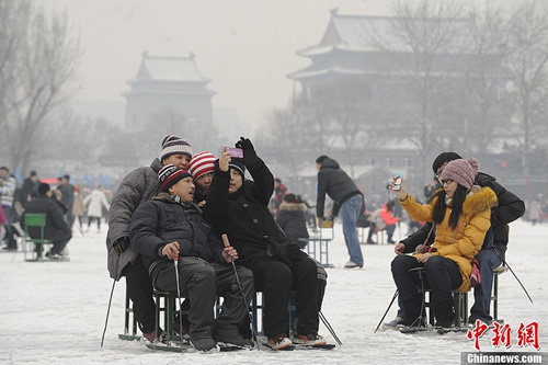 资料图：北京市民在冰场游玩拍照片留念。当日是中国传统二十四节气中的最后一个节气大寒，也被称为冬天最冷一日，同时亦有“过了大寒就是年”的民俗说法。中新社发 崔楠 摄