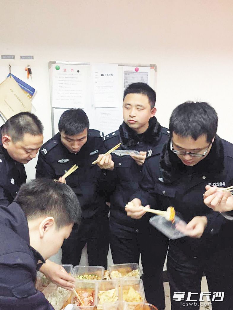 除夕之夜，定王台派出所的值班民警在派出所一起吃盒饭。受访者供图