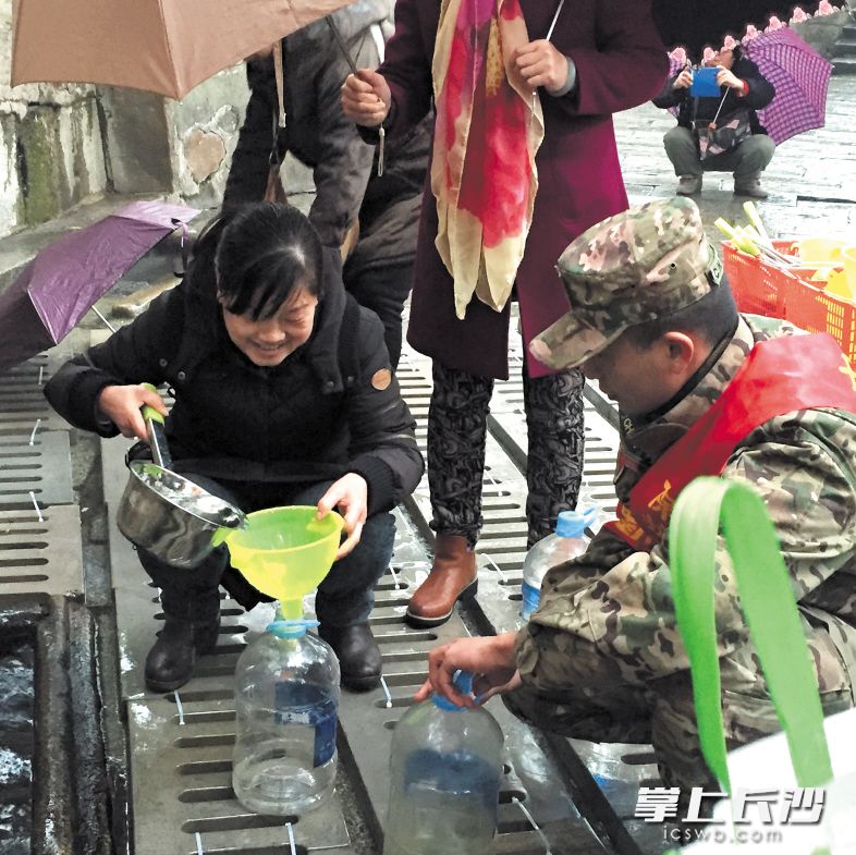 今年春节期间，有一群退伍老兵一直坚持在白沙古井值守，让市民取到干净清洁的井水。 长沙晚报记者 谢春年 摄 