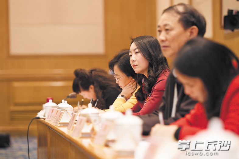 →湖南代表团全团会议上，张晓庆（右三）在认真审议政府工作报告。