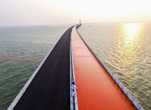 正在铺设沥青的港珠澳大桥江海航段桥面，红色是铺设沥青前的保护涂层(4月29日摄)。