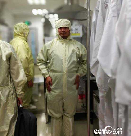 记者“全副武装”才能进入无尘车间。（央视网 记者 何川摄）