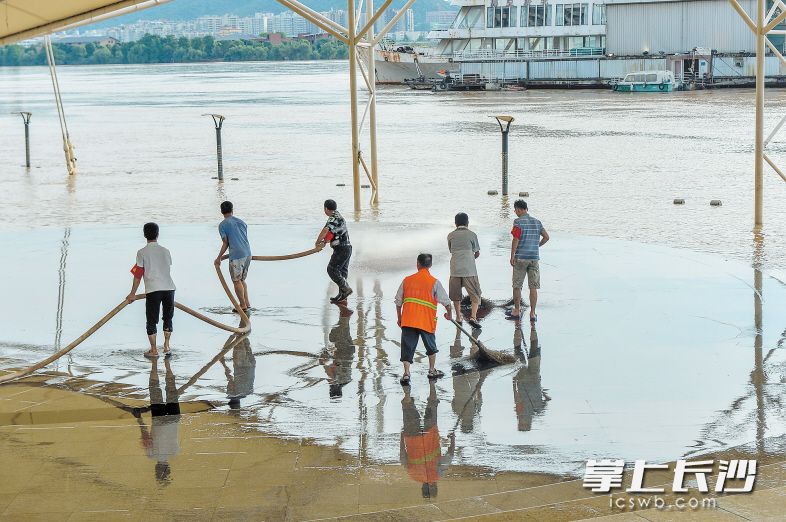 7月6日上午9时，志愿者正在清理风帆广场亲水平台上的泥渍。