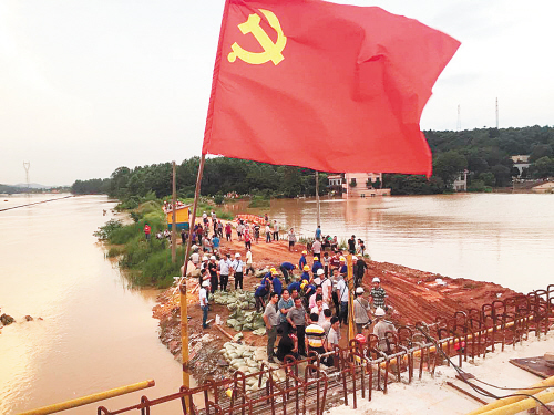 在抢险现场，高高飘扬的党旗激励着人们奋战洪魔。